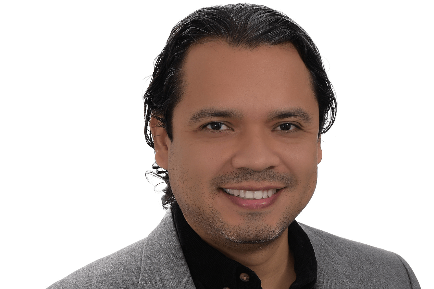 A man wearing a dark shirt and grey jacket 