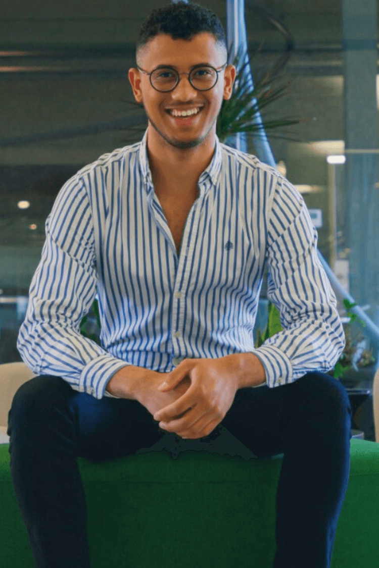 Ein Mann saß auf einer Bank und trug ein blaues Hemd. 