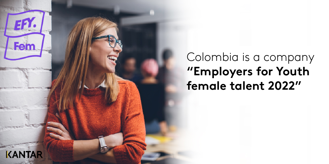 Une femme en pull orange contre un mur. Le texte se lit comme suit : "Colombia is a company "Employers for Youth female talent 2022"" : La Colombie est une entreprise "Employeurs pour les jeunes talents féminins 2022".