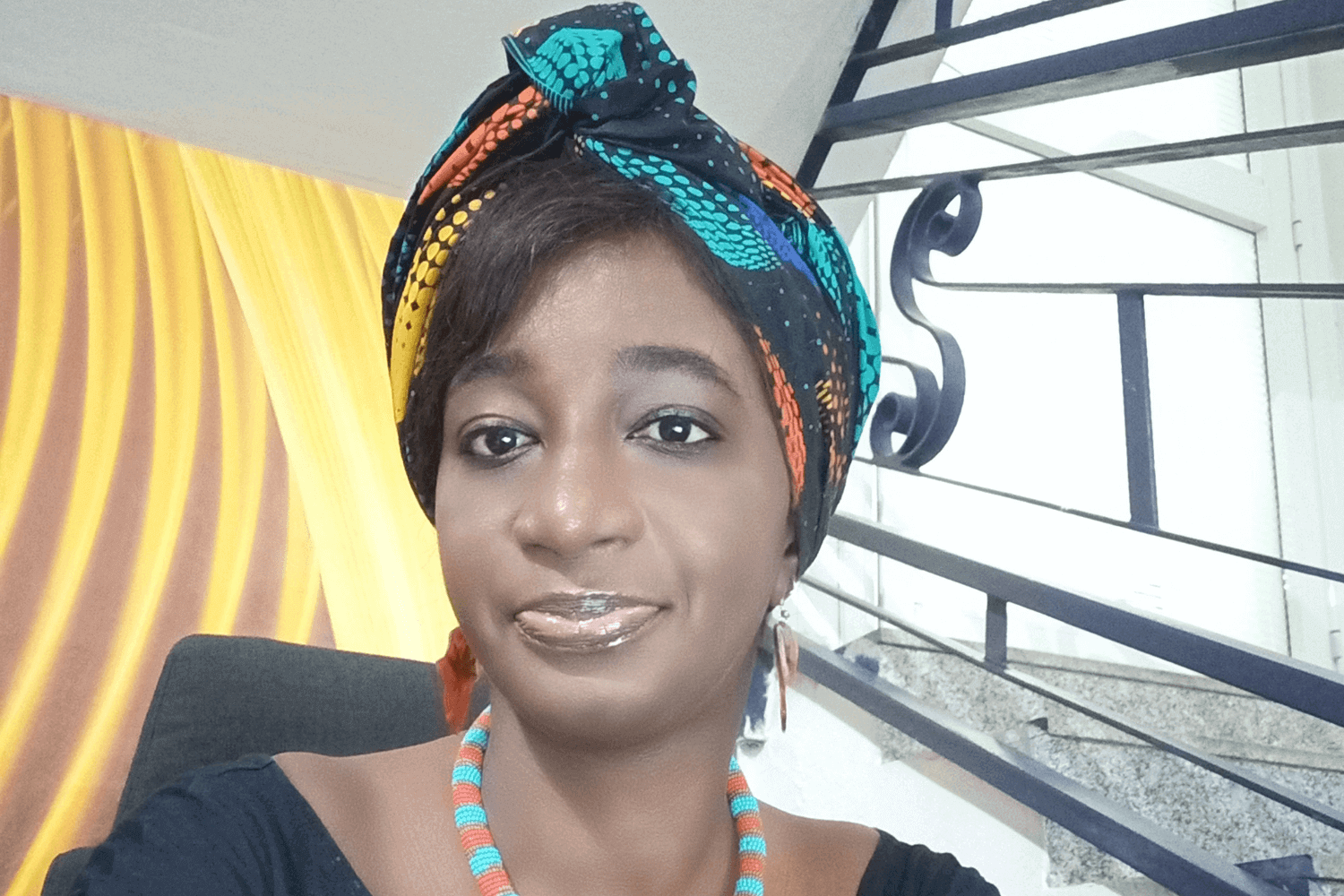 一位身穿蓝色上衣、头戴五彩头巾的女士。