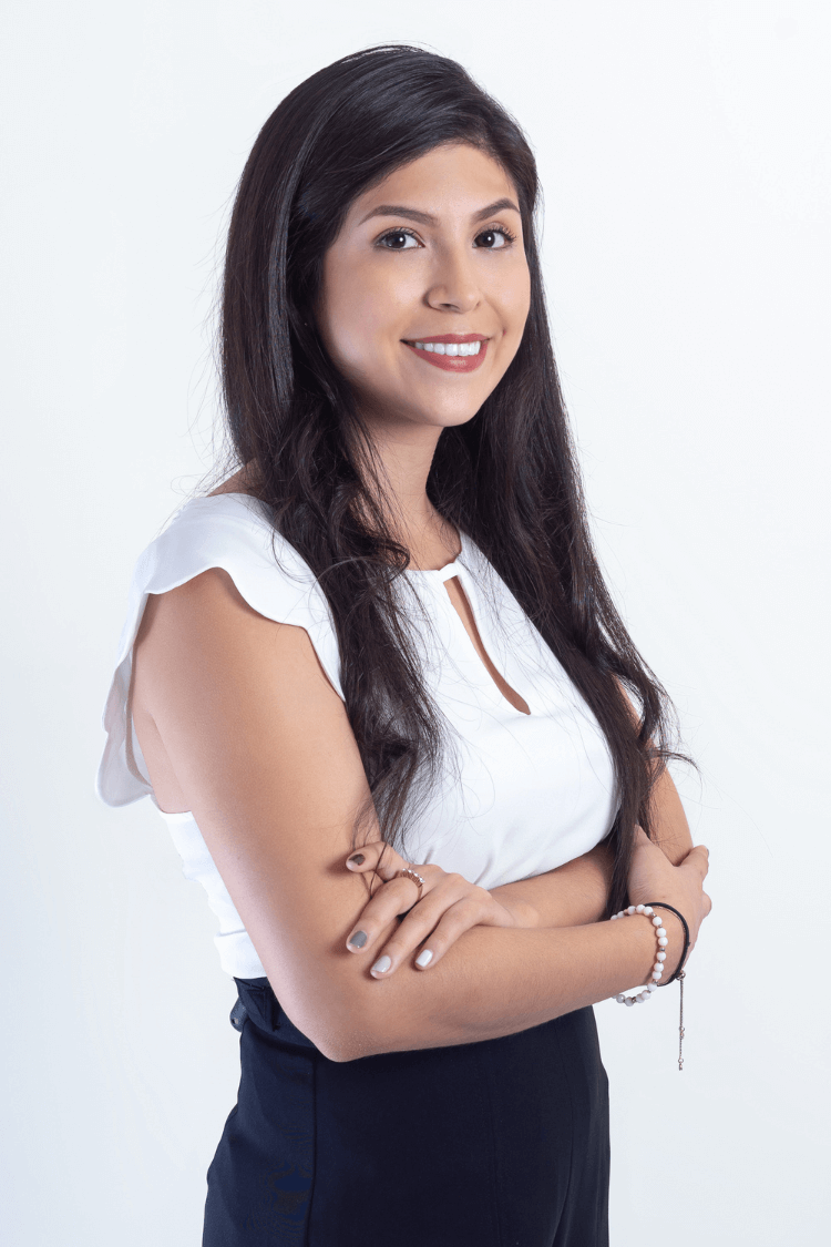 一位深棕色长发的女性。她双手合十，身穿白色短袖上衣。